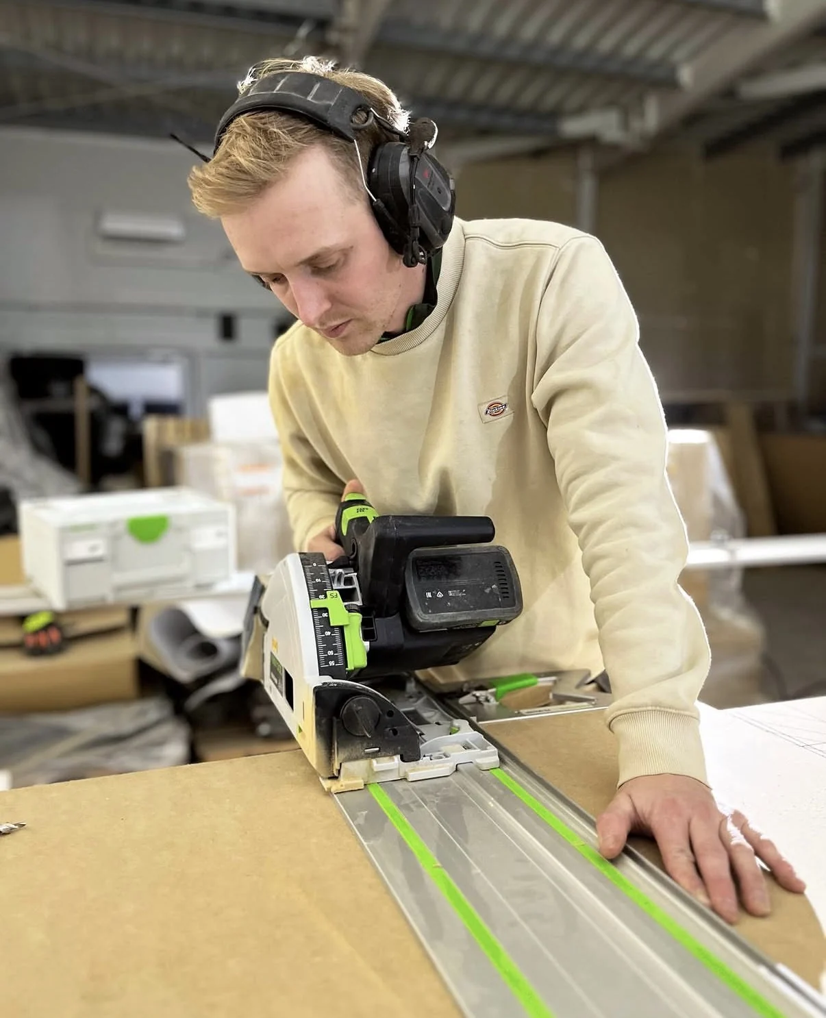 Nicolai fra FD Møbeldesign kapper plate med kappesag i verkstedet